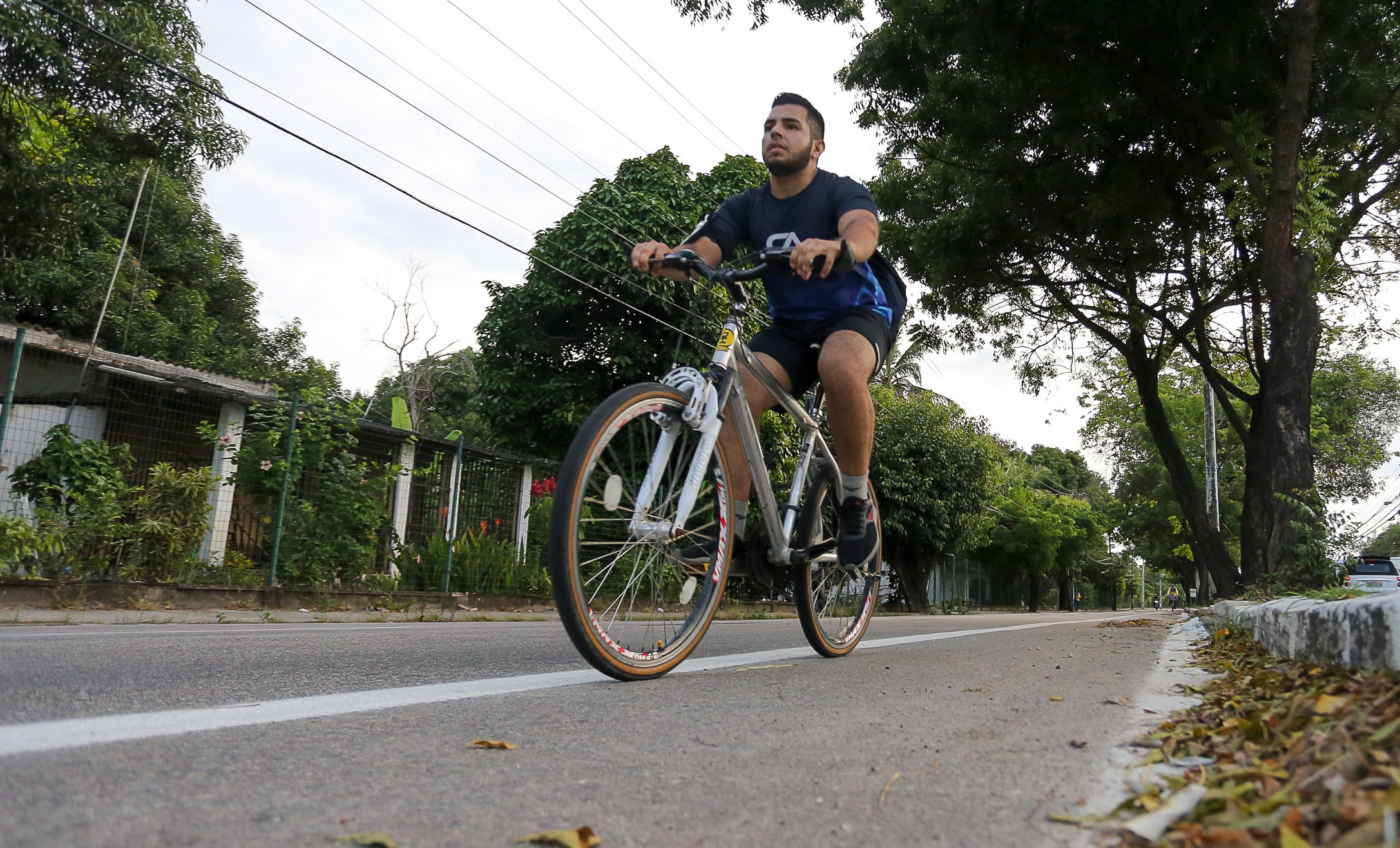 Ciclista pedalando em ciclofaixa em avenida