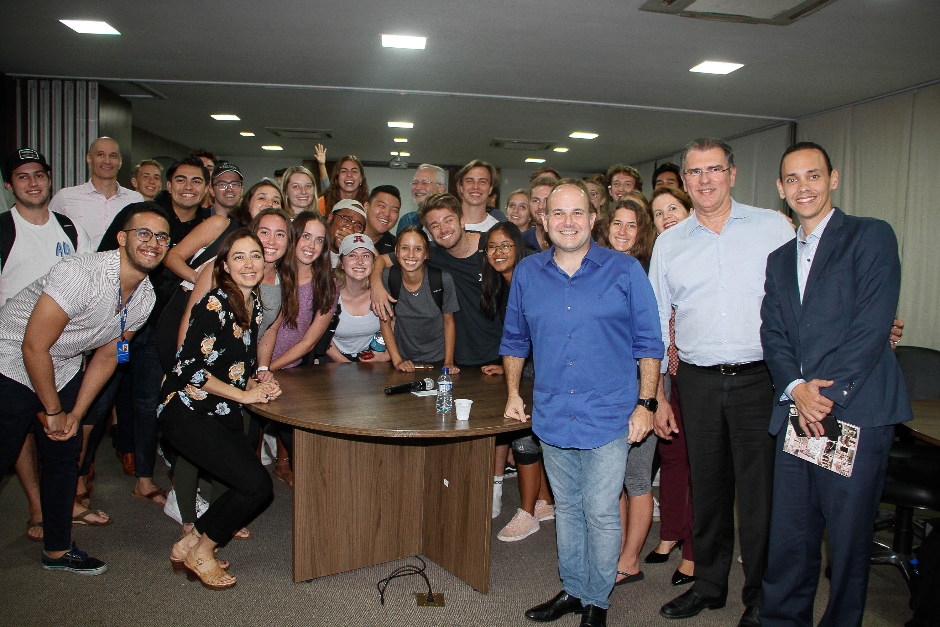 Prefeito em pé com grupo de jovens ao fundo sorrindo