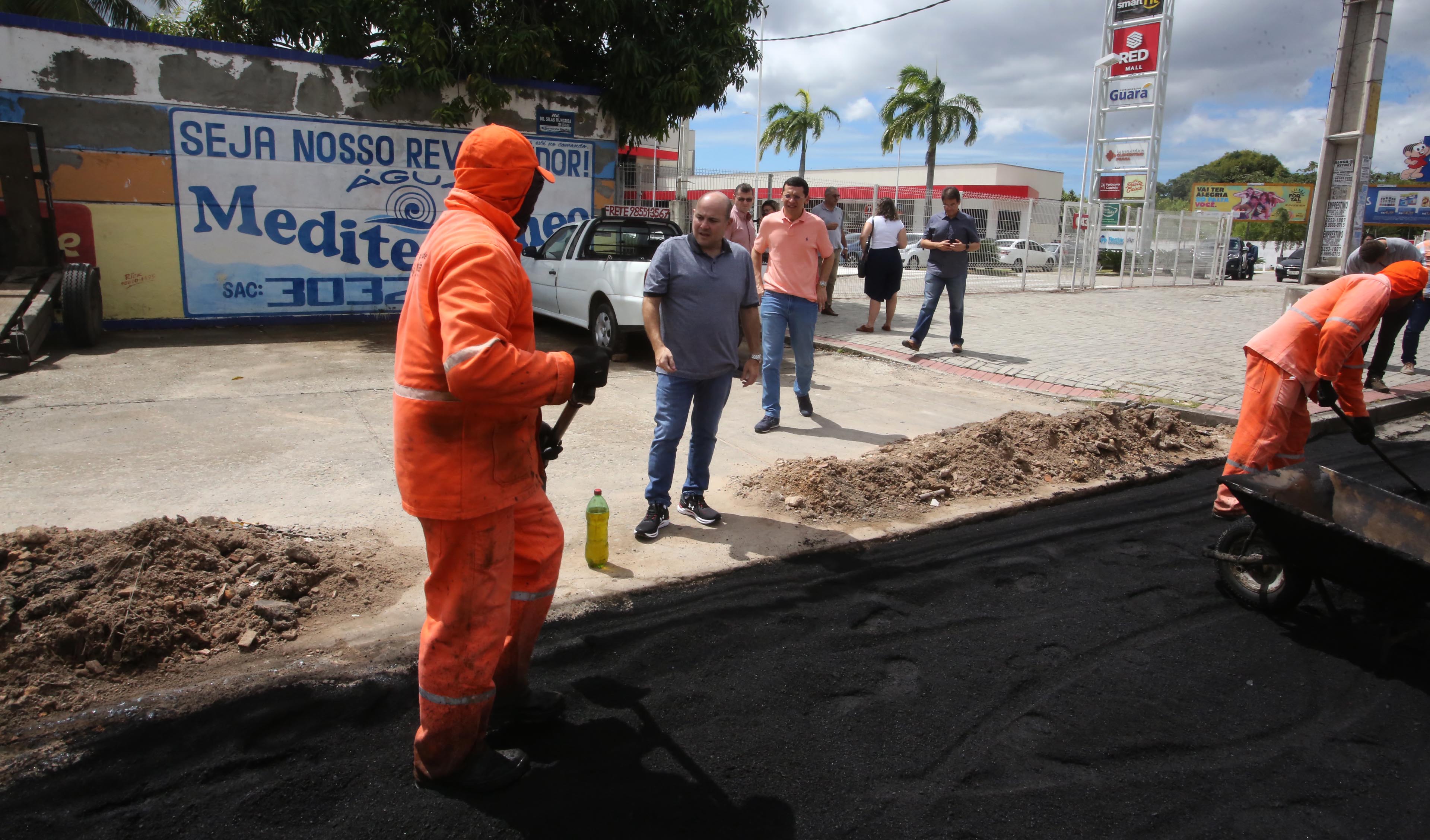 Prefeito em rua vendo homens trabalhando em obra no asfalto