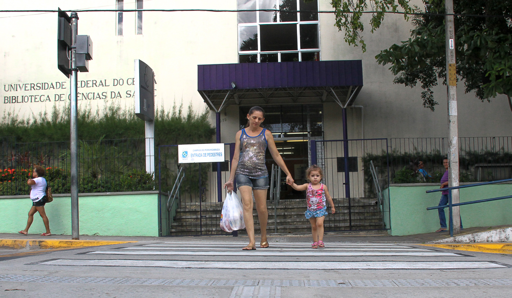 mulher e criança atravessam faixa de pedestre