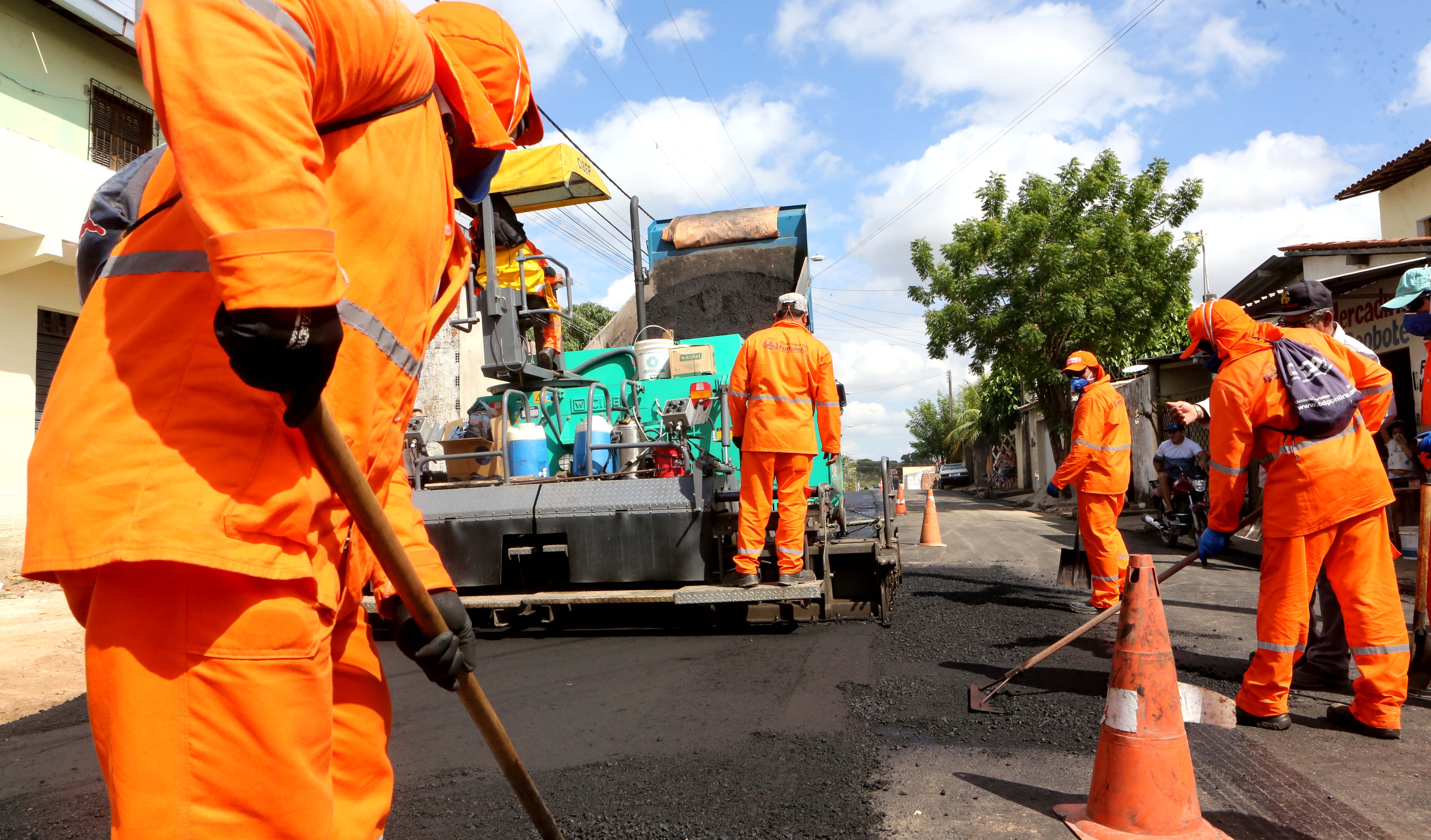 Homens implantando novo asfalto em rua