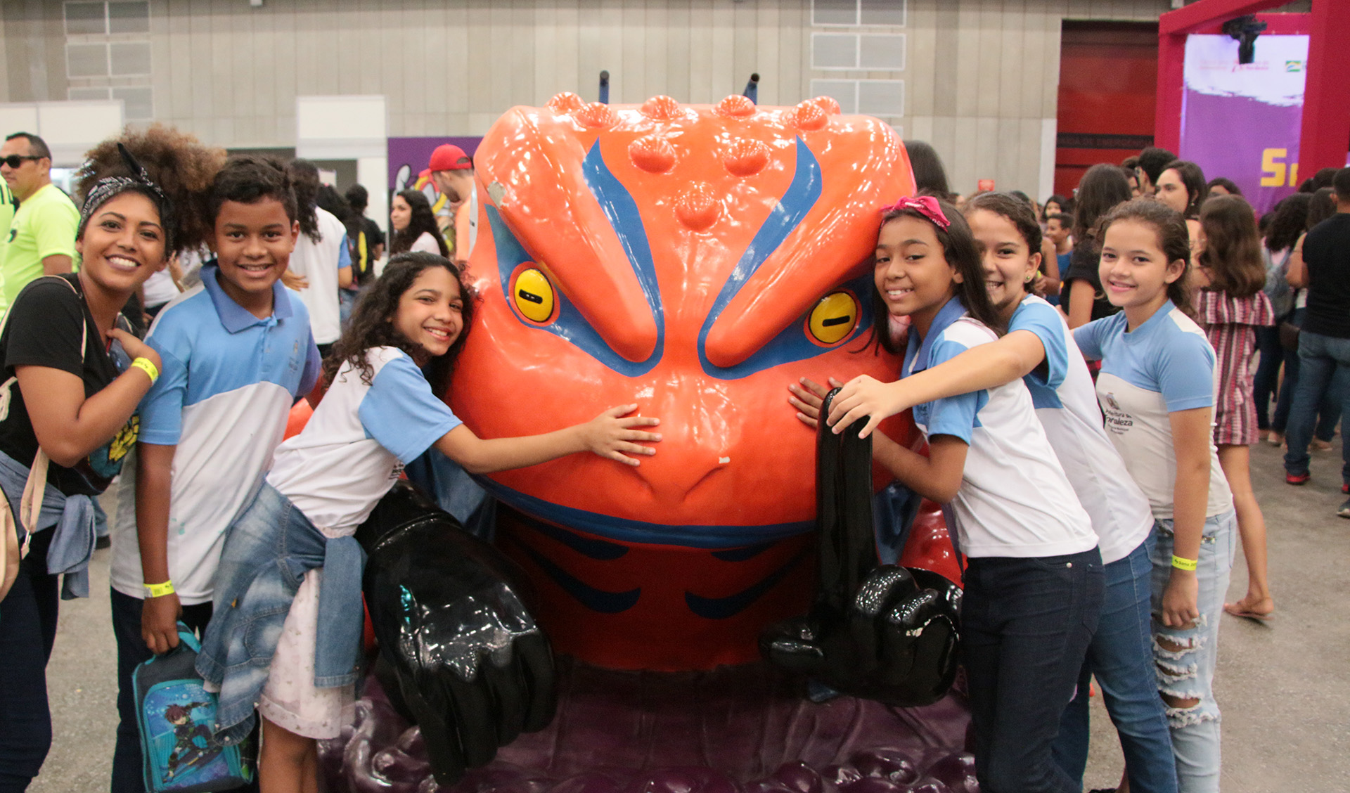 Crianças abraçadas com escultura de dragão