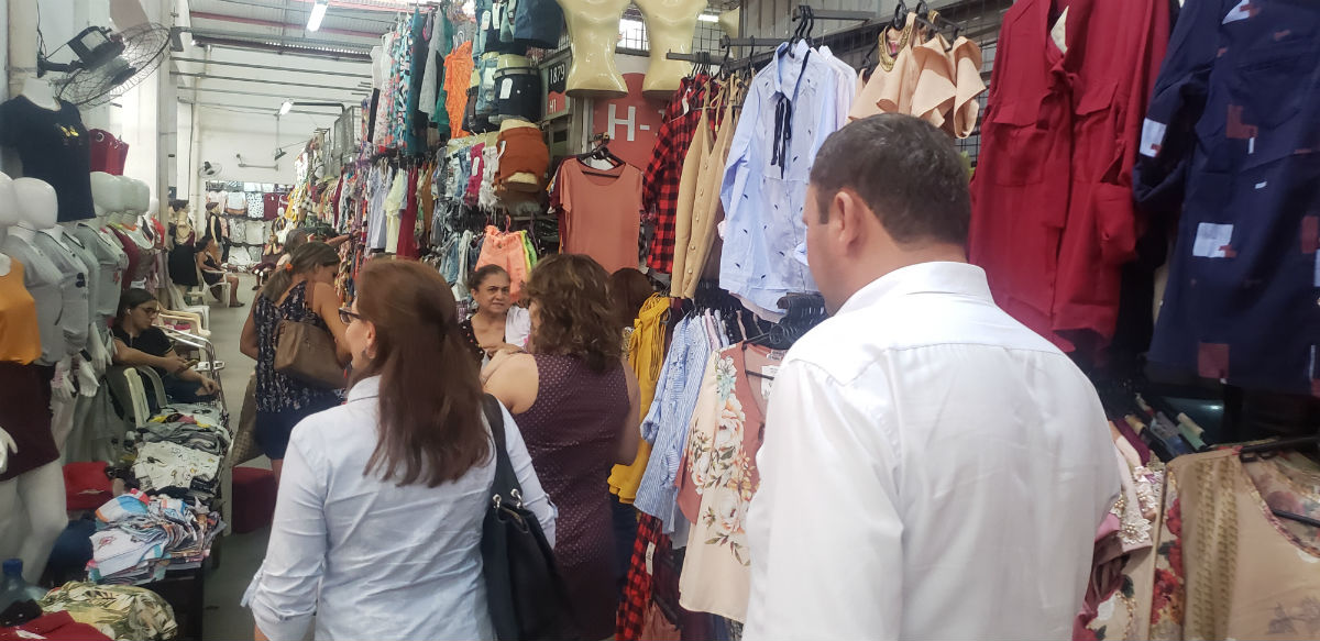 Pessoas de costas caminhando por um mercado