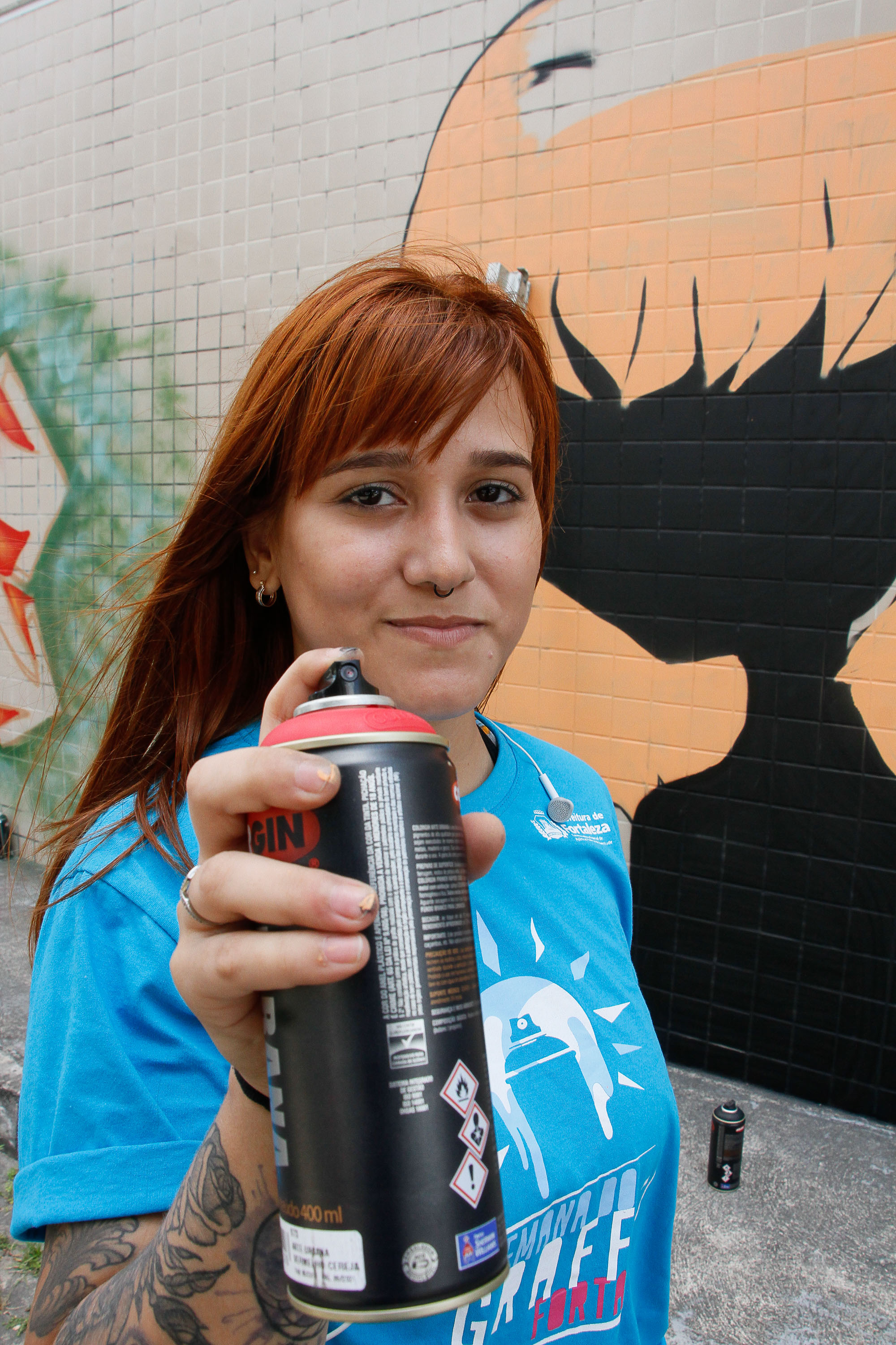 mulher mostra uma lata spray de tinta
