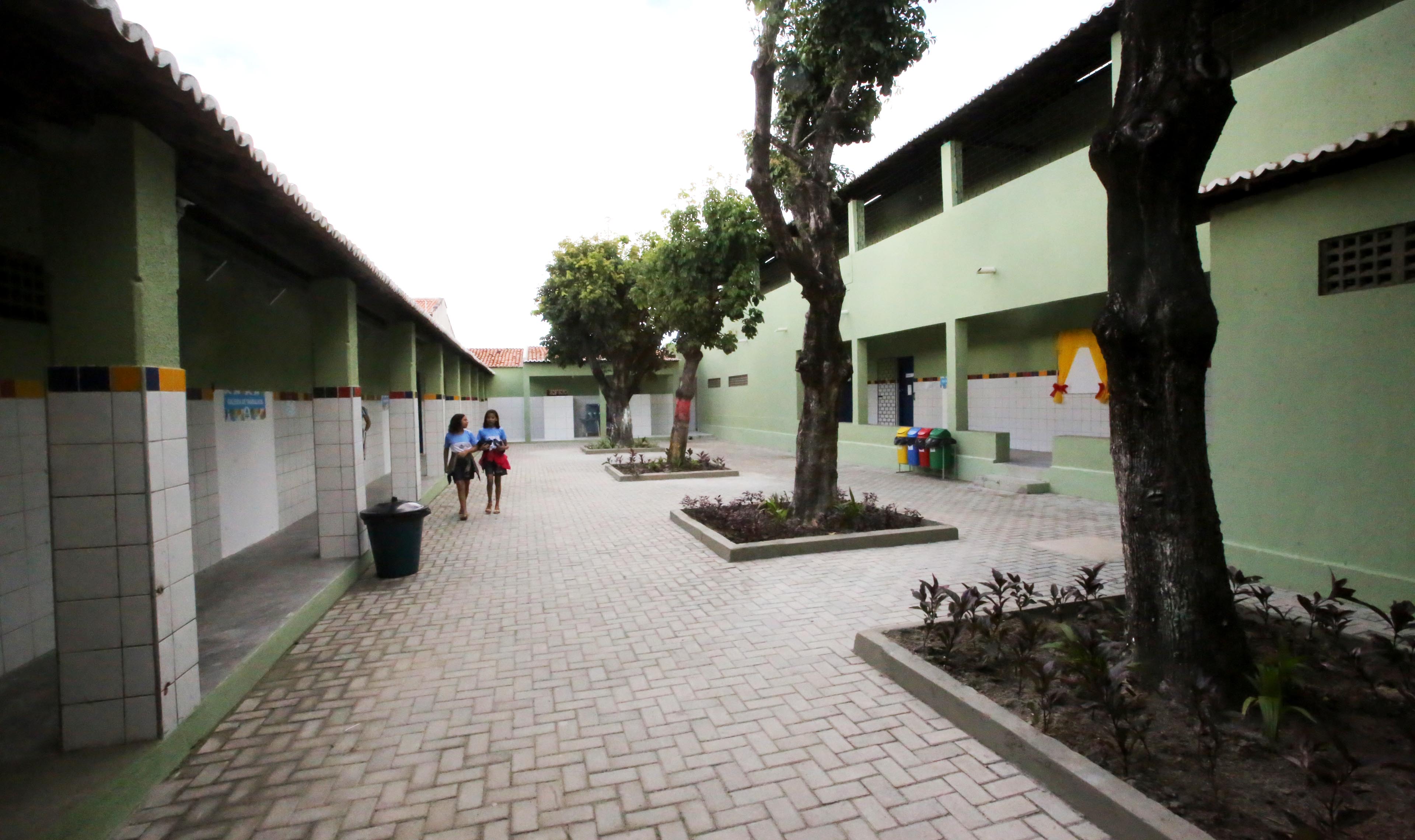 Pátio de escola com árvores e corredores