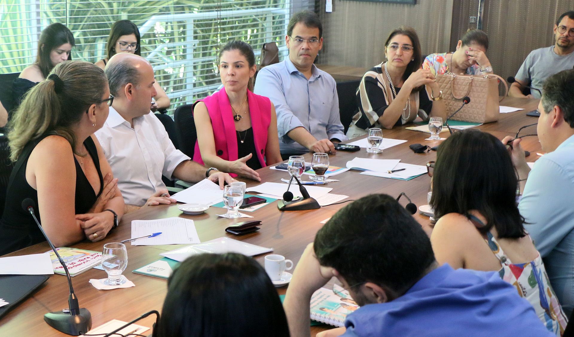 Prefeito, primeira-dama e outras pessoas conversando ao redor de mesa