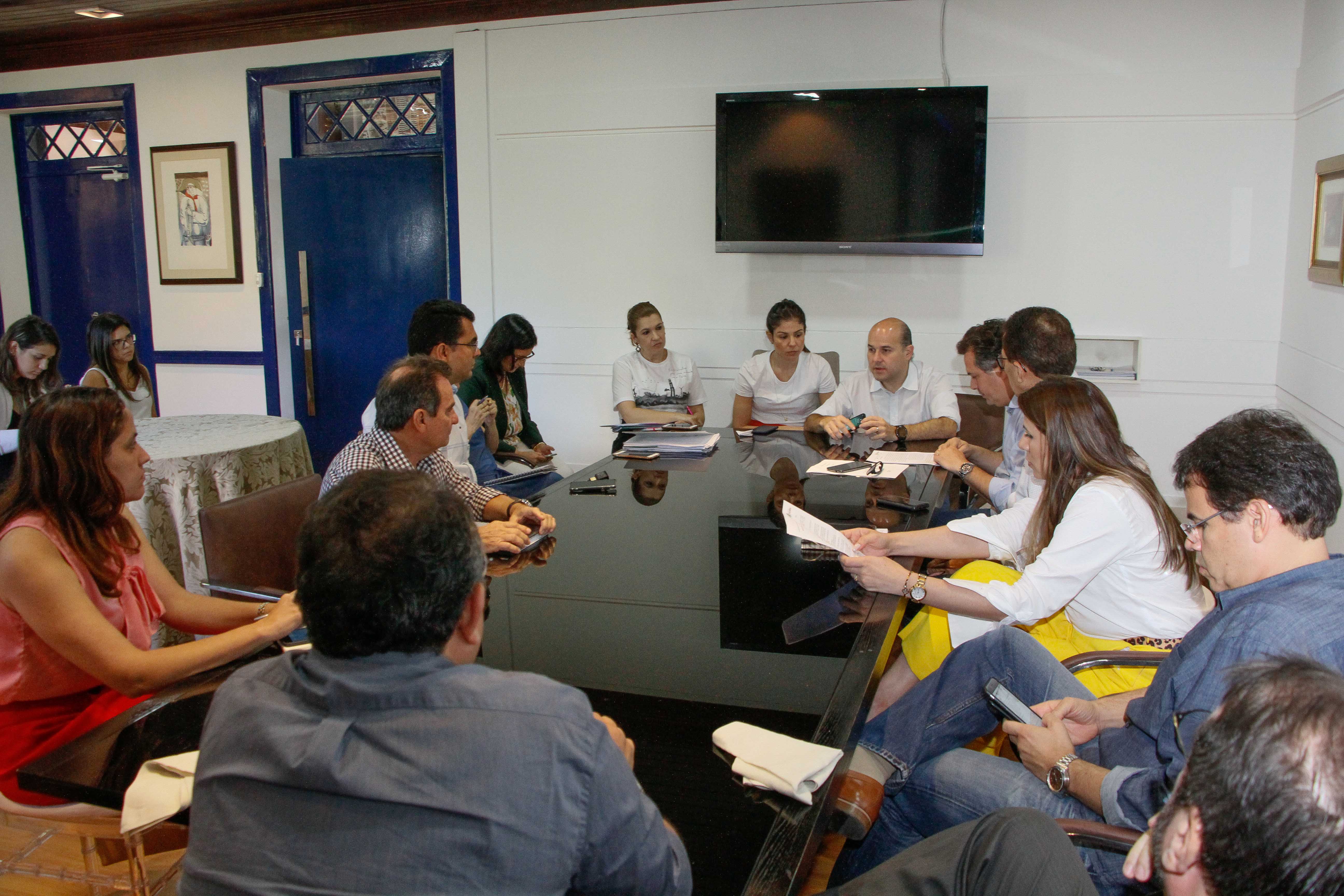 Prefeito e primeira-dama sentados à mesa com pessoas ao redor