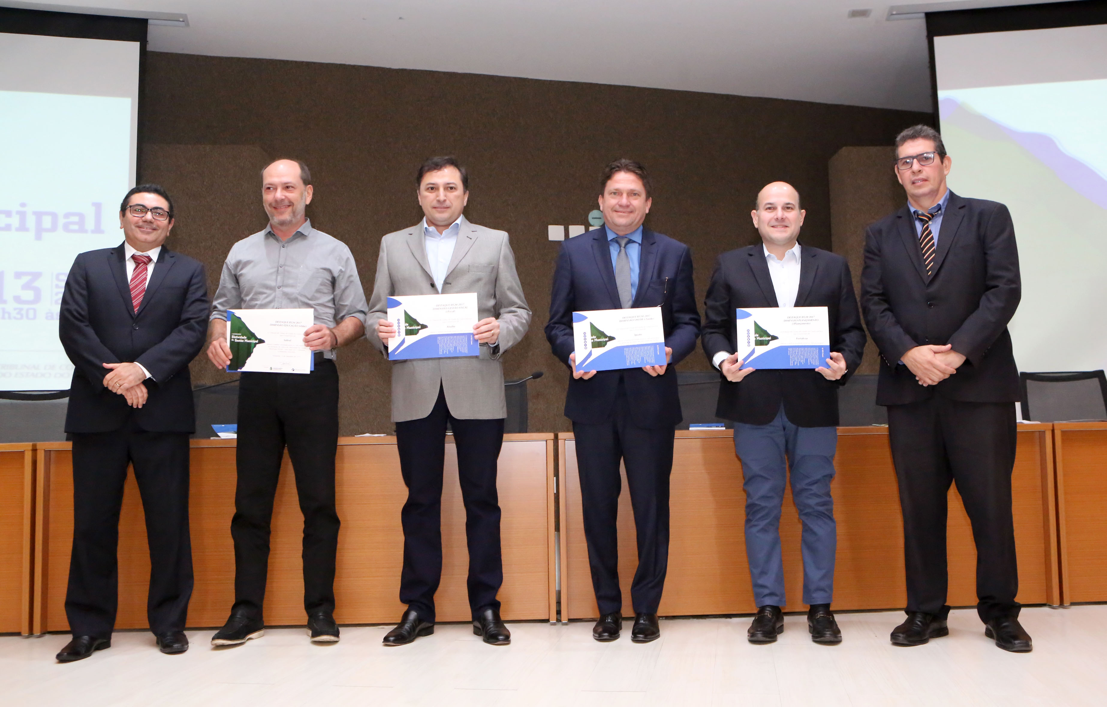 pessos posando para foto segurando certificados