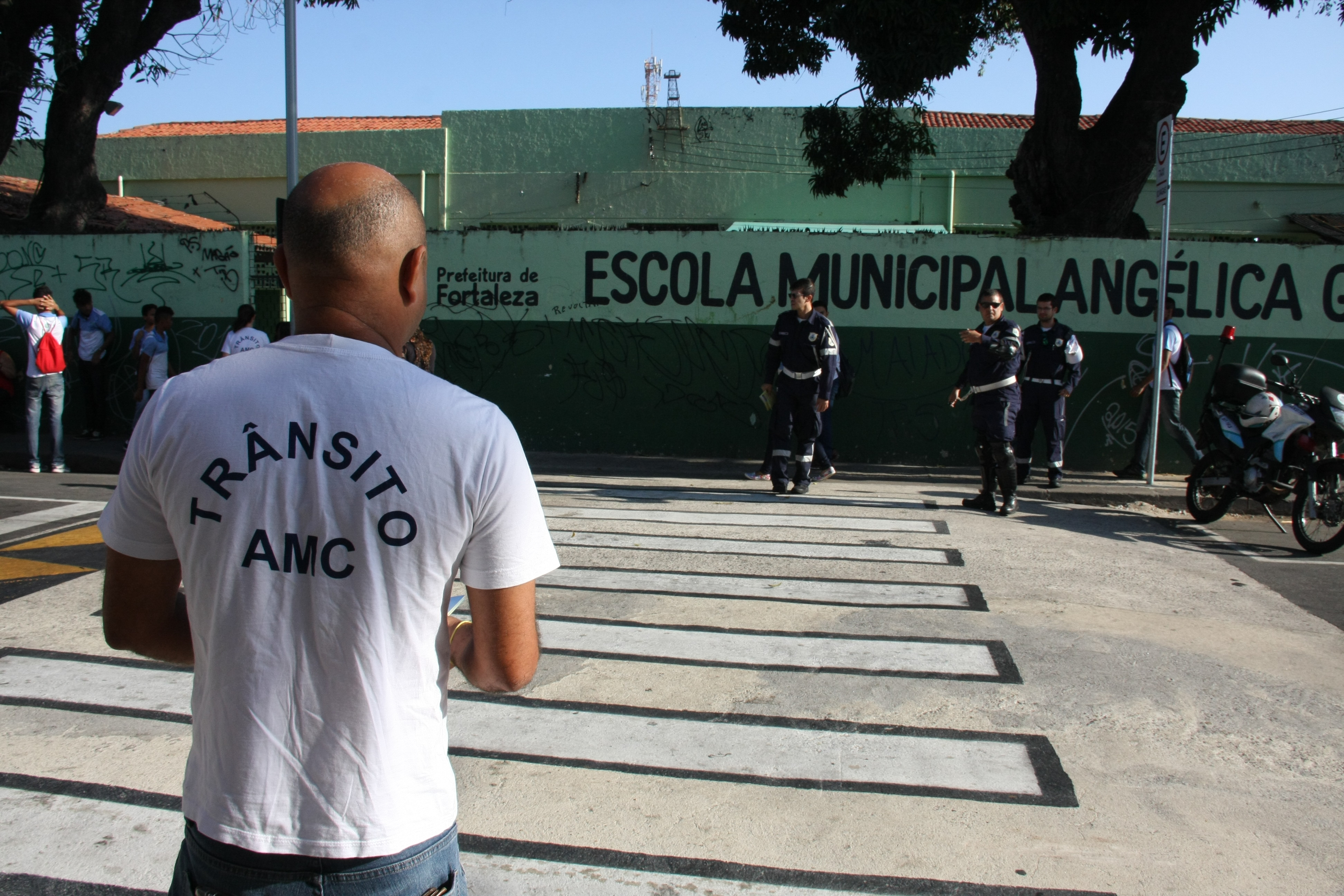 agente da amc em frente a uma escola