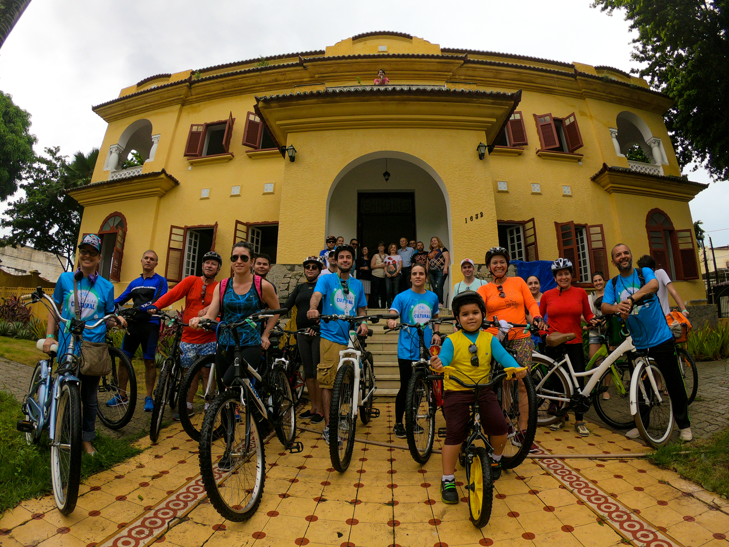 Numeroso grupo de ciclistas participante da Ciclofaixa Cultural posam ao lado de suas bicicletas em frente à fachada do Centro Cultural Casa do Barão de Camocim
