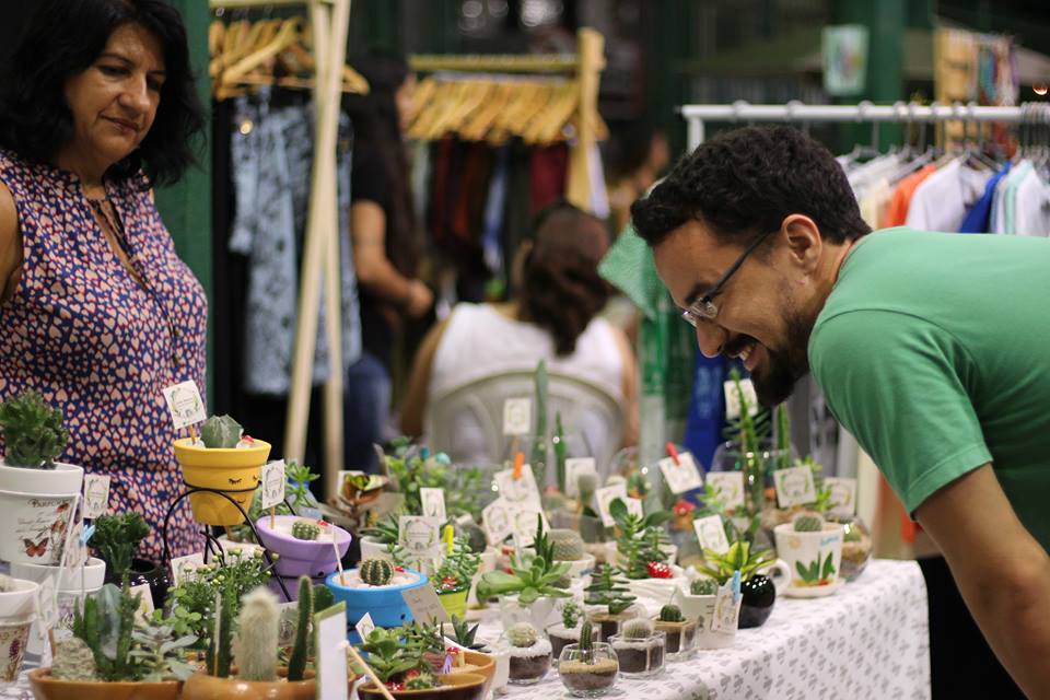 Homem observa plantas vendidas em feira no Mercado dos Pinhões