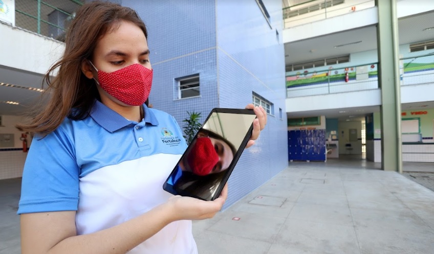 uma aluna com máscara usa um tablet