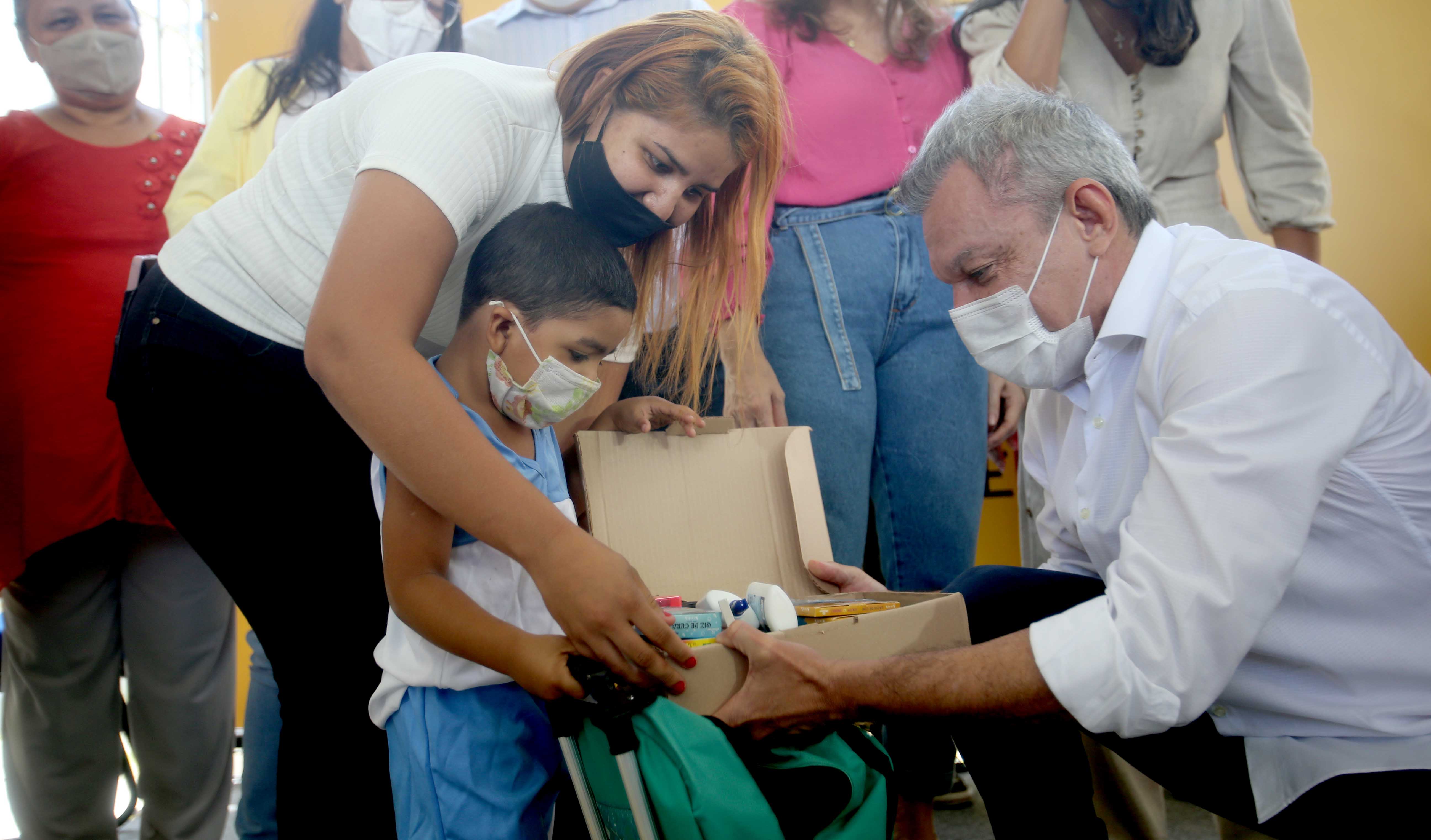 prefeito entrega um kit escolar para um aluno