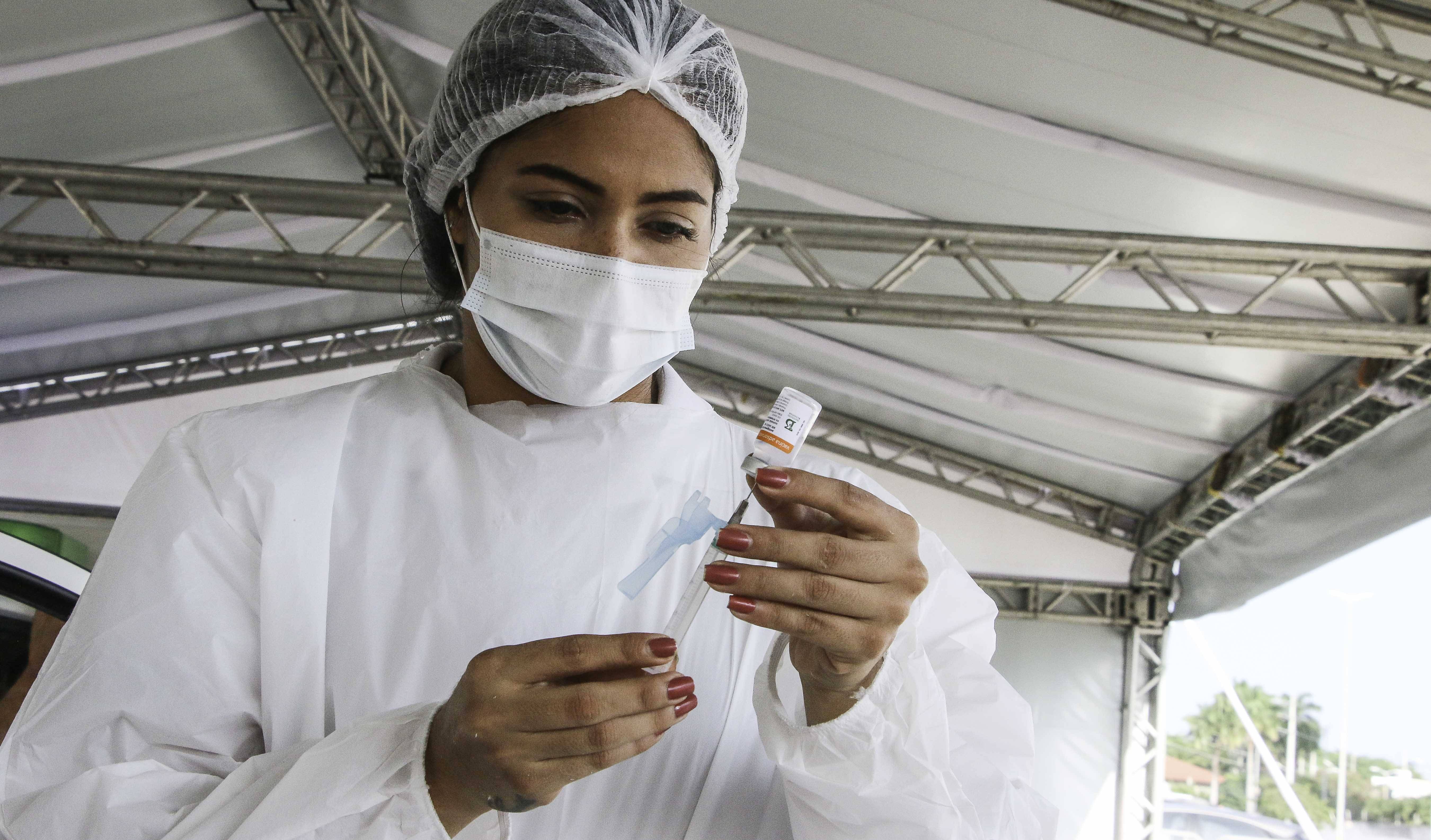 enfermeira ajusta uma seringa de vacinação