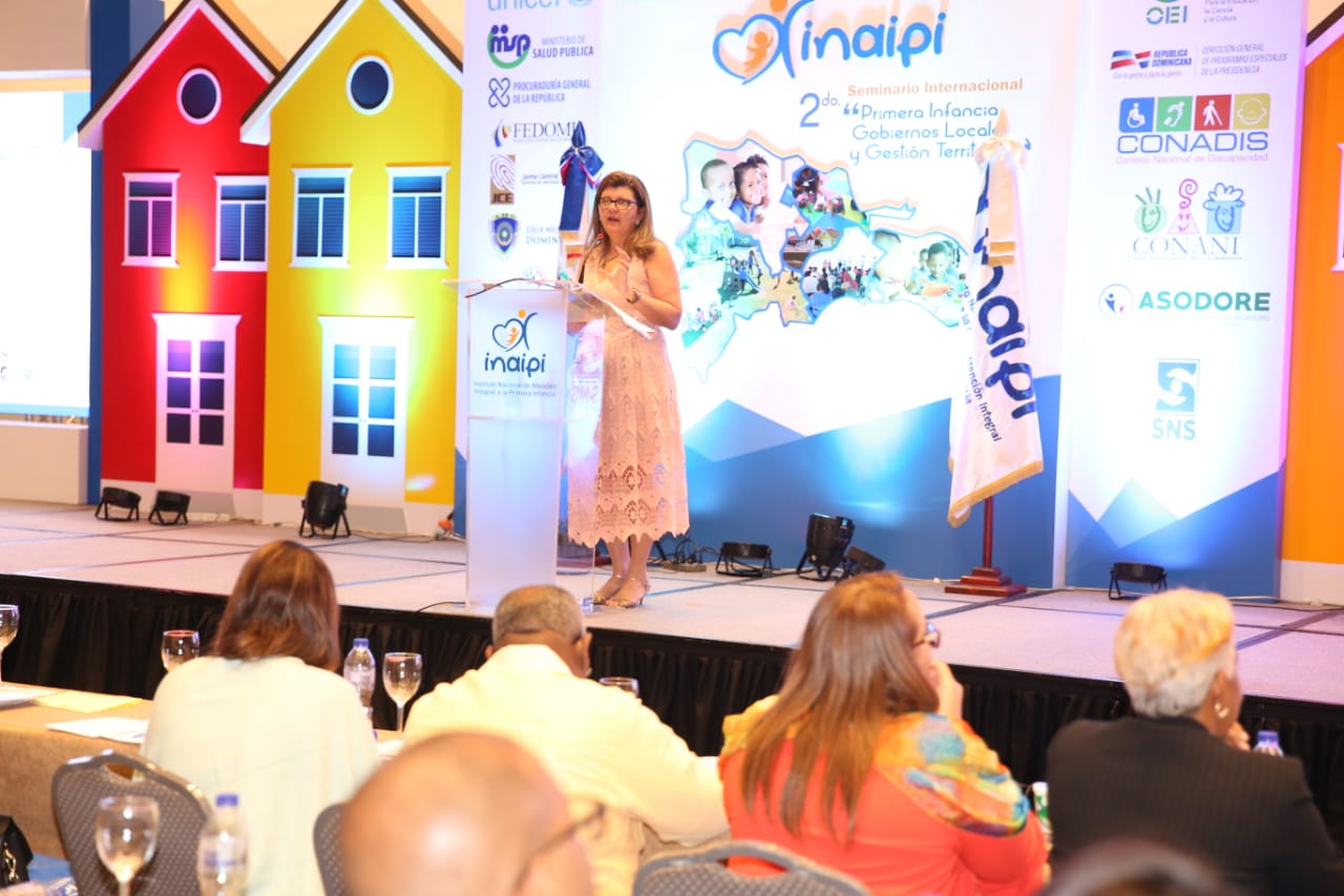 secretária falando em cima de palco para plateia