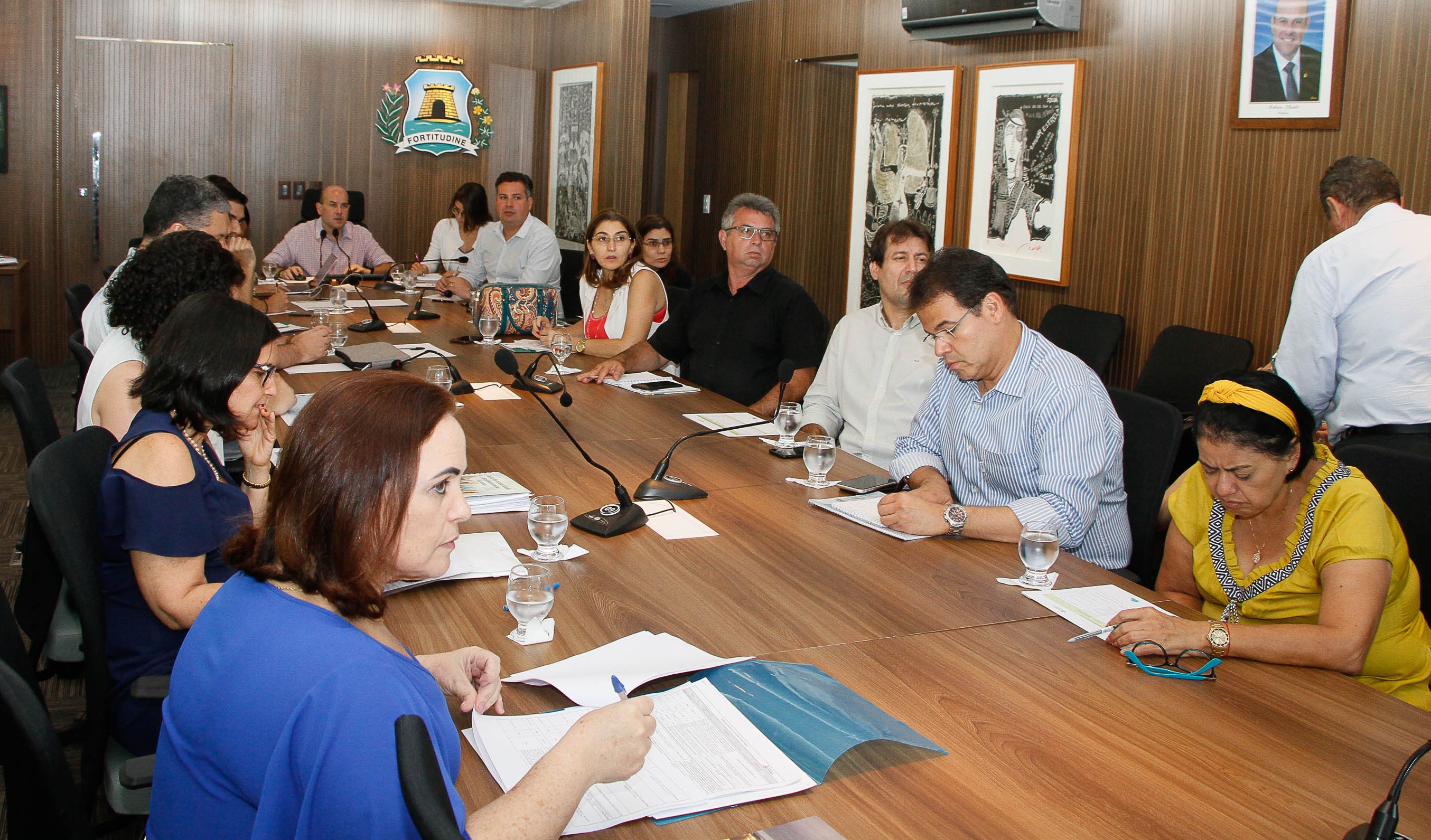 Prefeito sentado à mesa ao lado de secretários