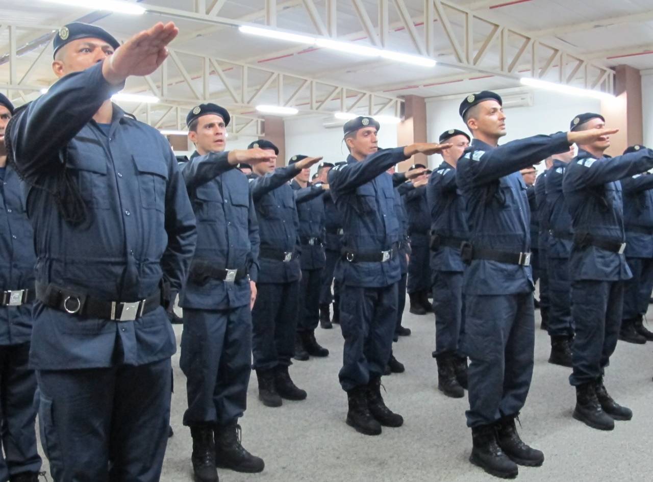 guardas em pé enfileirados em posição de juramento com braço direito levantado na frente do corpo