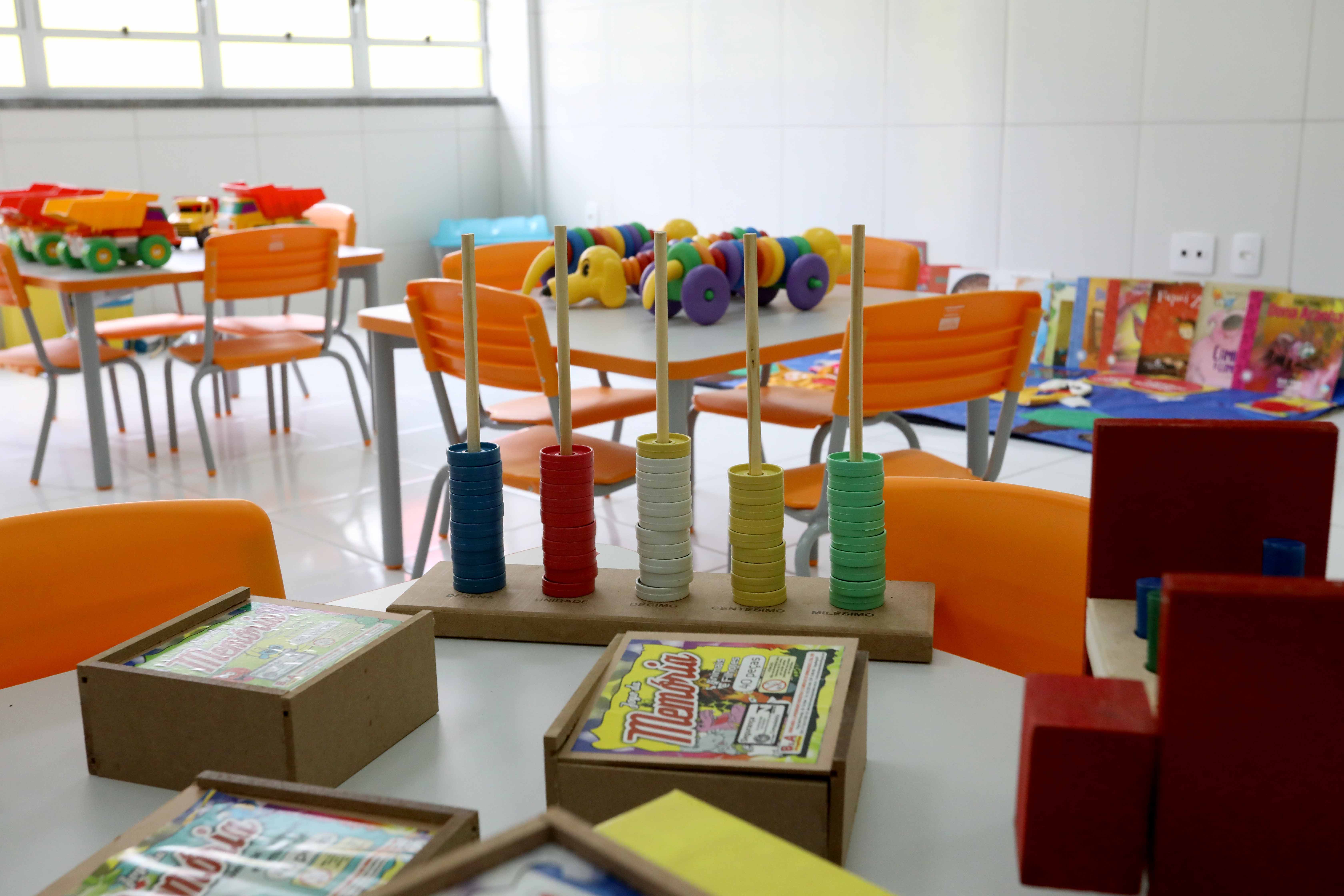 sala de aula de creche com mesas e cadeiras coloridas e brinquedos
