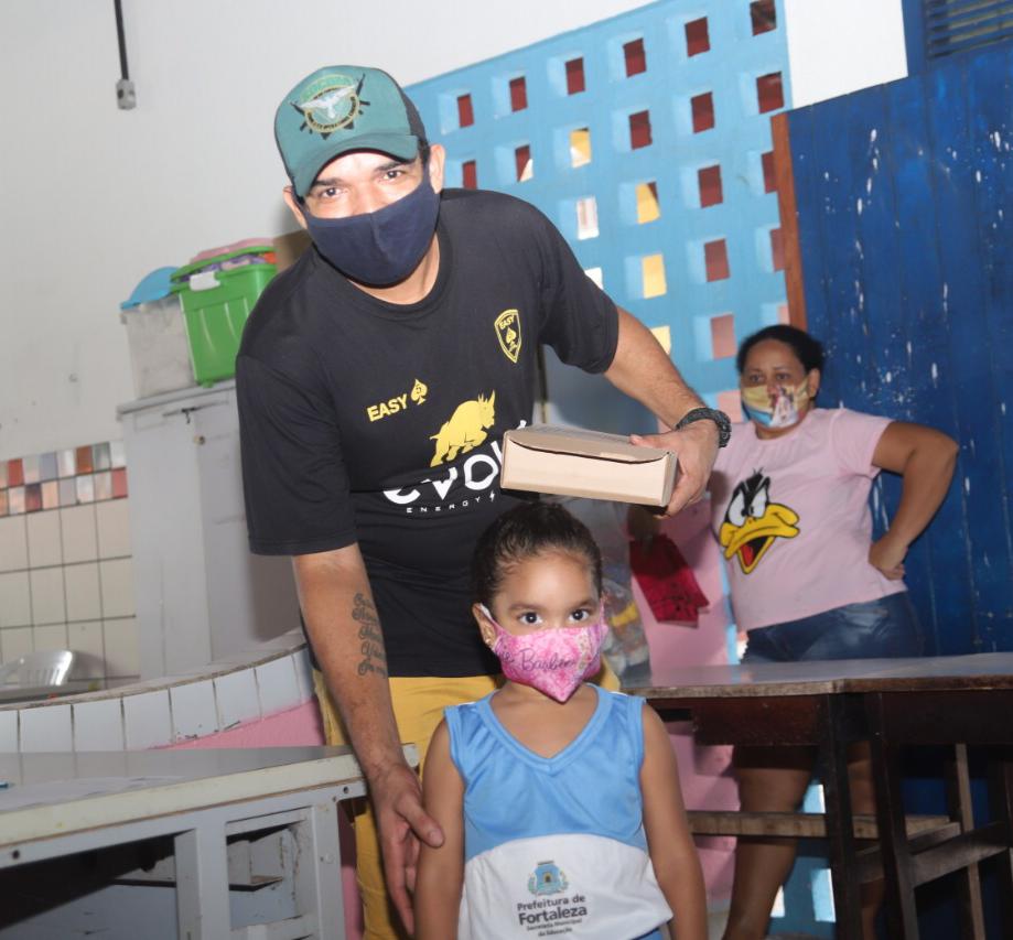 Aluna Maria Valentina e seu pai, Francisco Lima, no momento da entrega do kit pedagógico Pai e aluna na escola