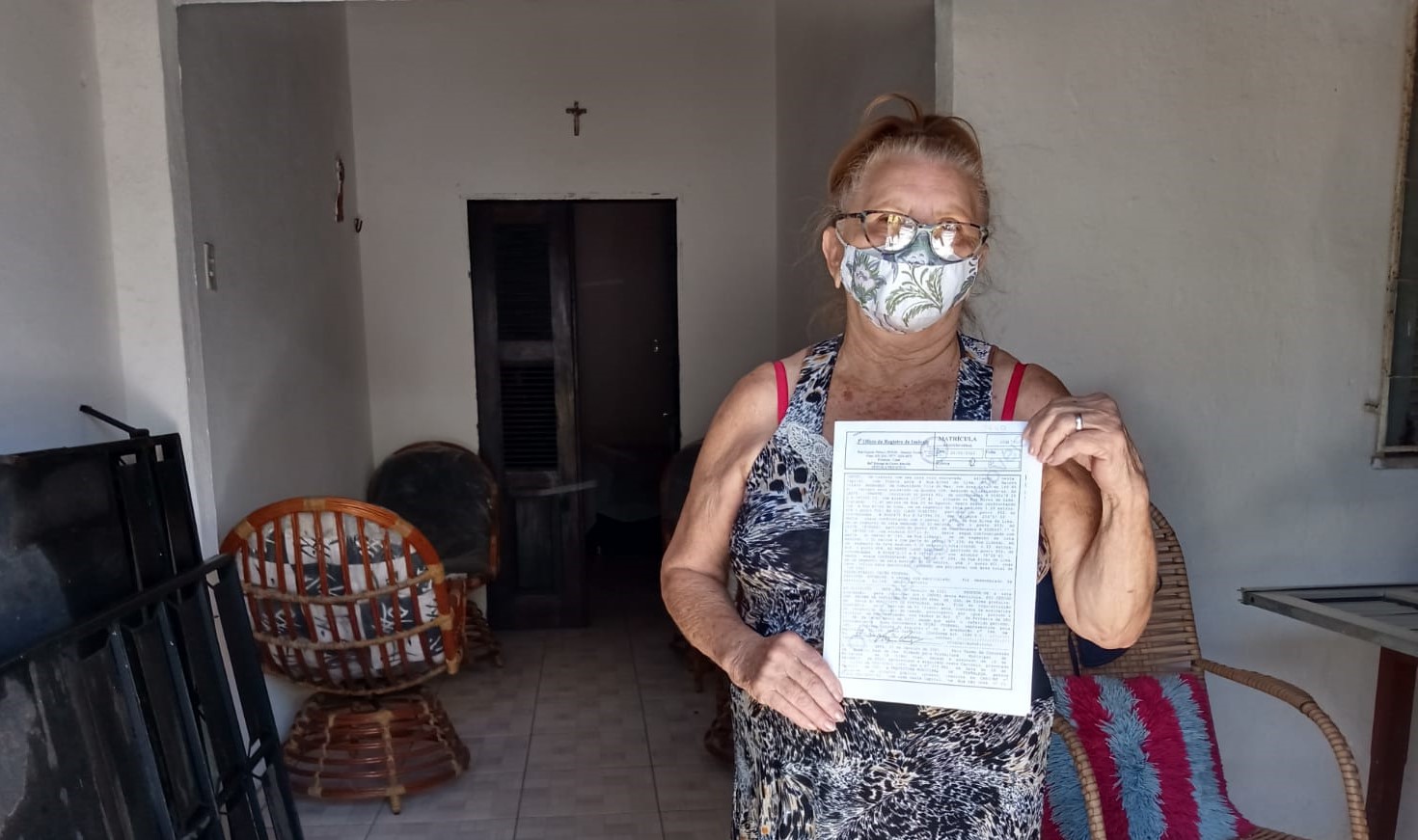 Dona Maria Ferreira Alves segura o papel na mão
