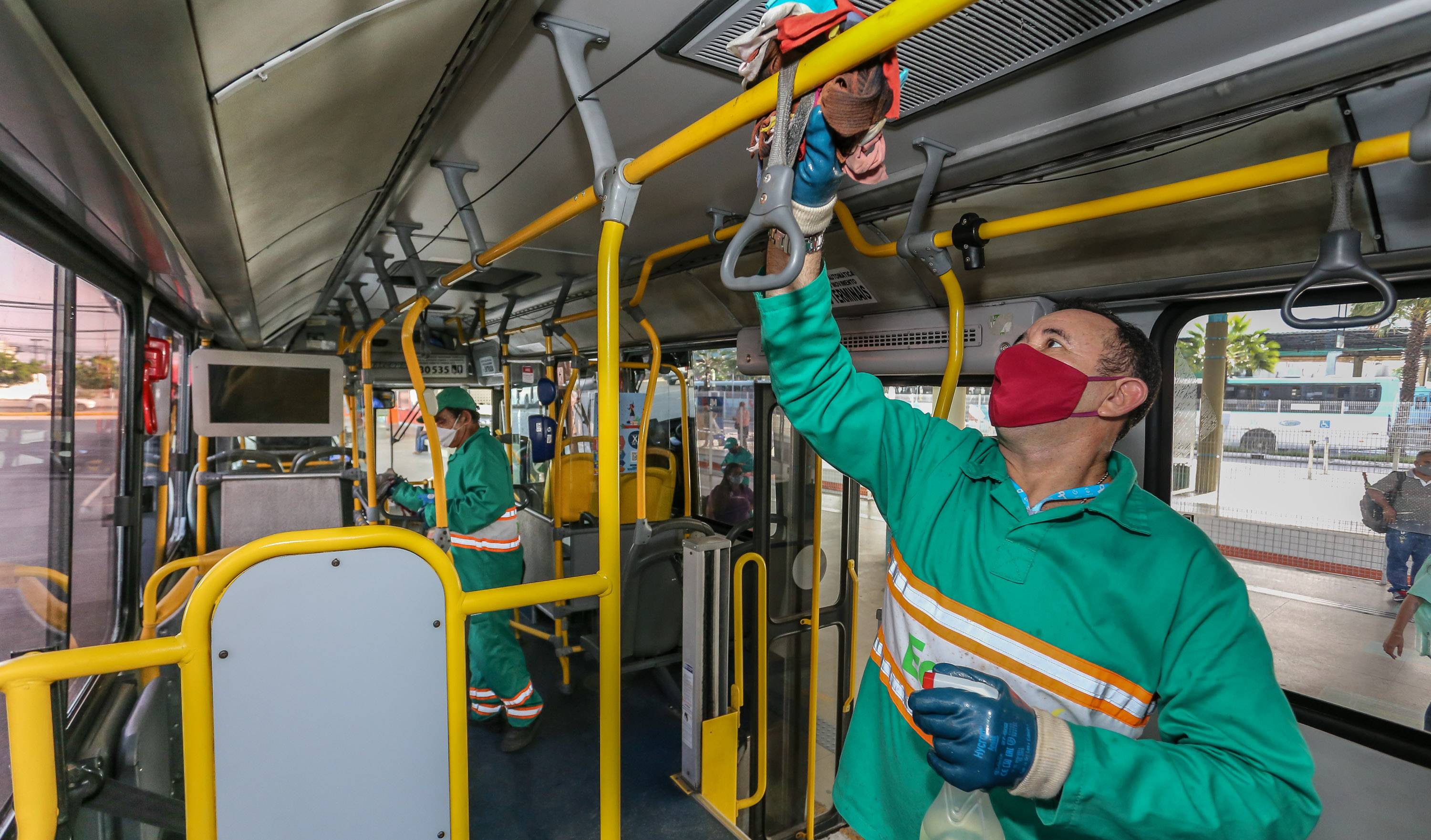 Funcionário realizando ação de desinfecção no ônibus