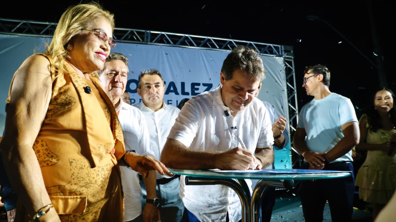 Prefeito Evandro Leitão assina autorização para construção de Areninha no Parque São José. O documento está sobre uma mesa de vidro.