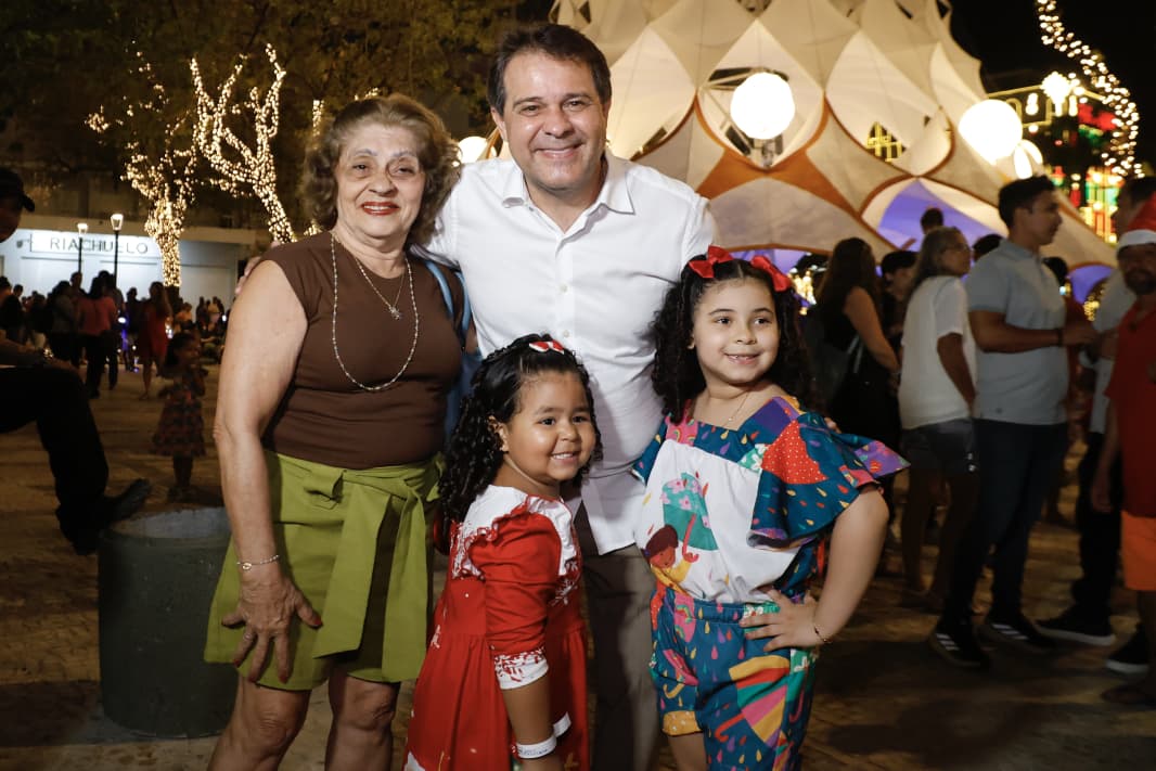 A imagem é um retrato do prefeito Evandro Leitão com duas crianças e uma mulher durante a abertura do Natal de Luz