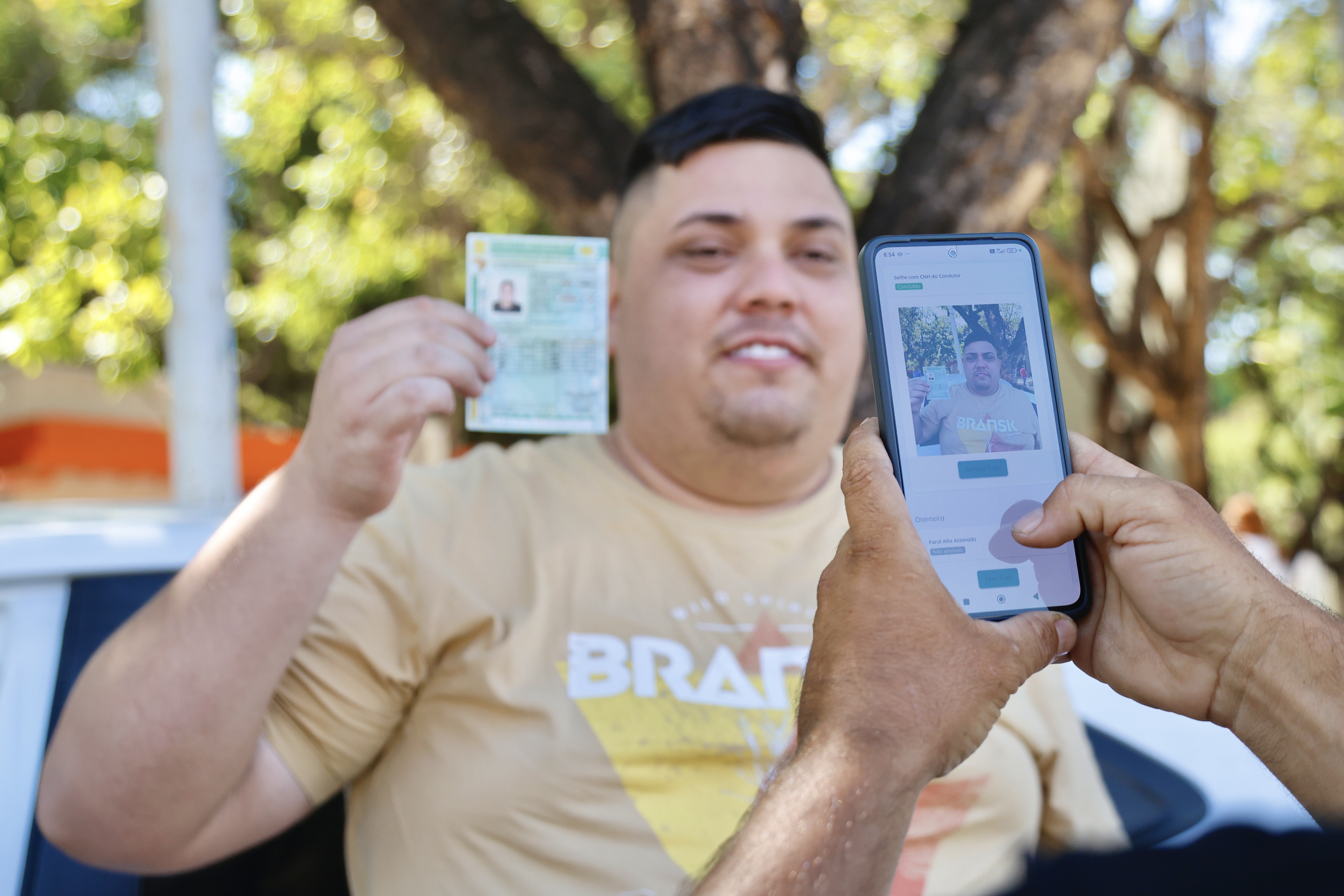 homem posa para a foto segurando um documento 