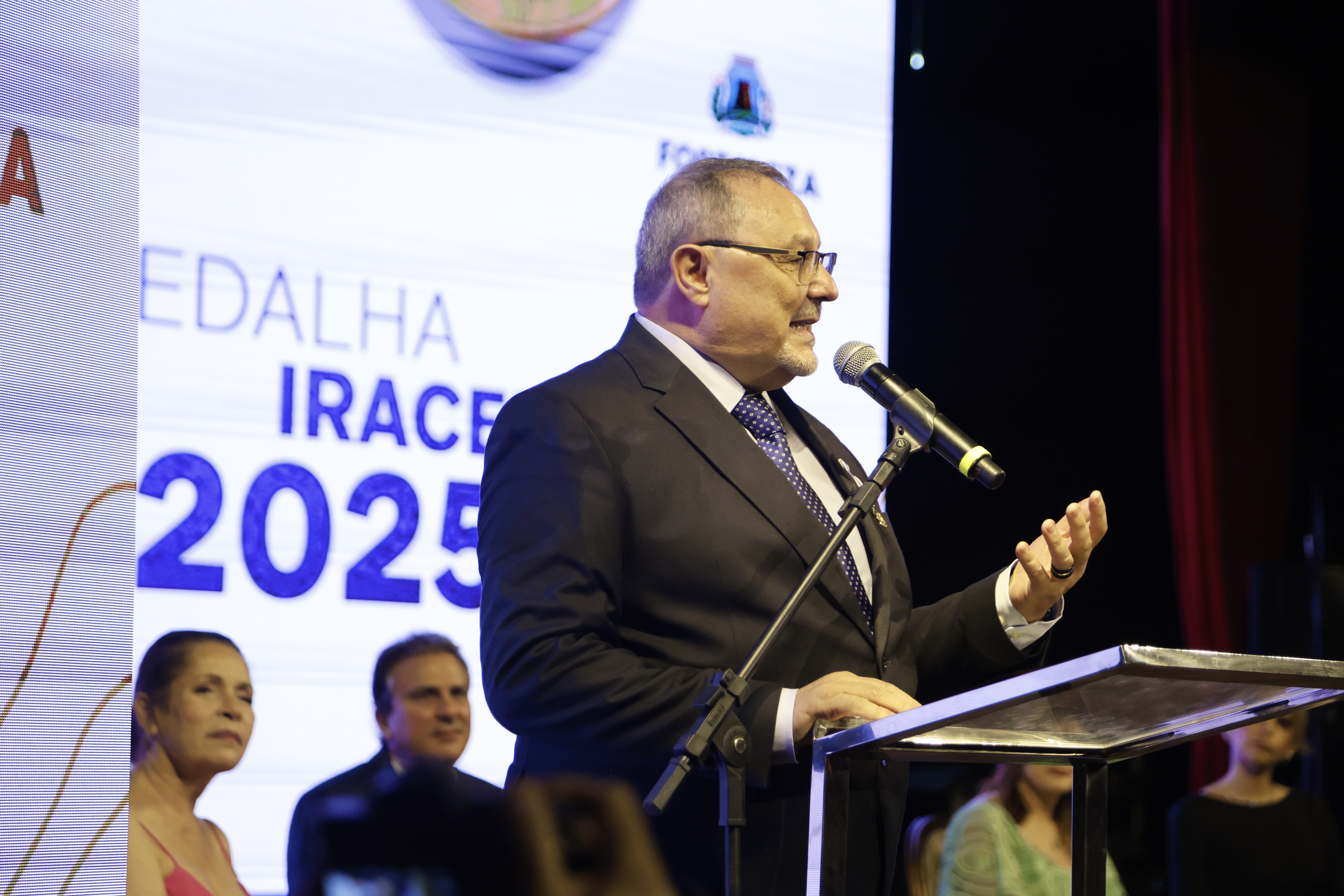 padre rino discursaando no palco