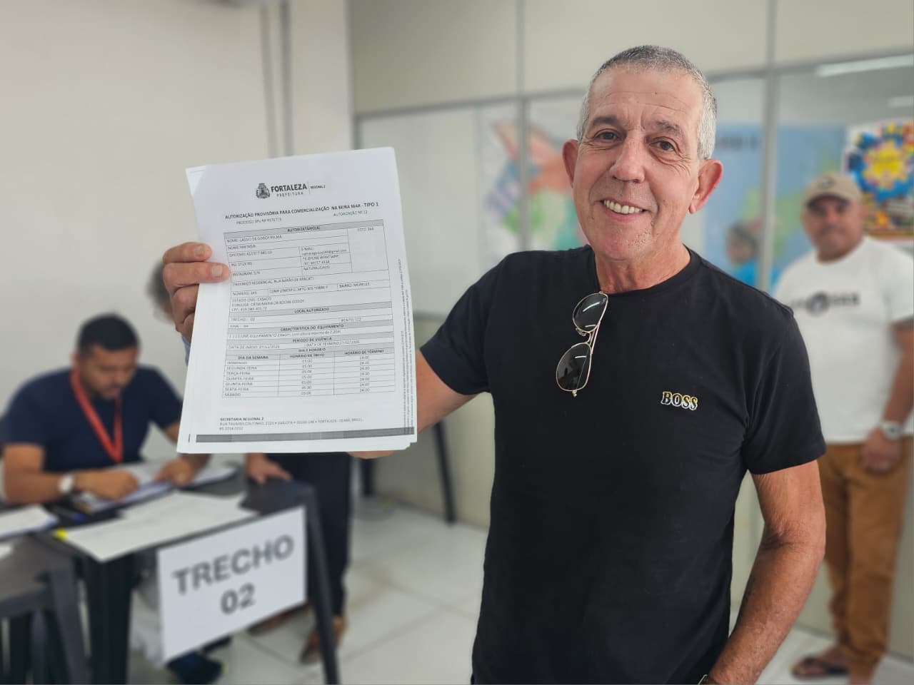 Permissionário Cássio Godoy sorrindo e recebendo termo de permissão na SER 2