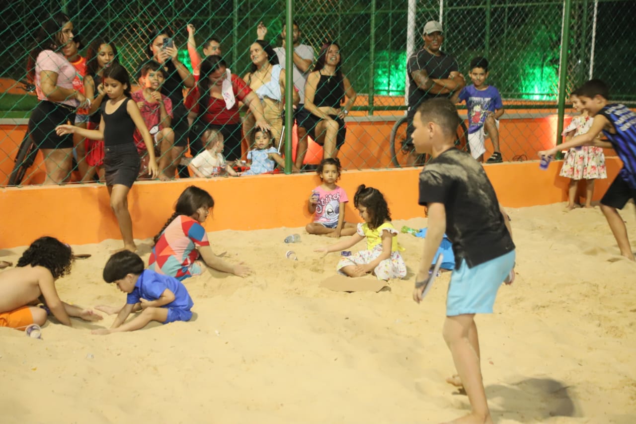crianças brincando numa quadra de areia