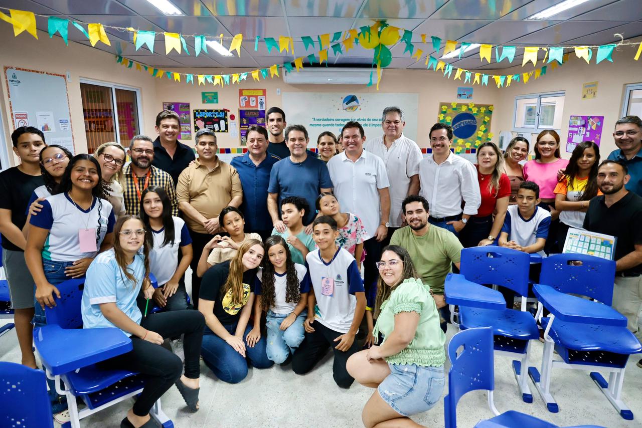 O prefeito Evandro Leitão posa para a foto com gestores e integrantes da comunidade dentro da Escola Areninha reformada