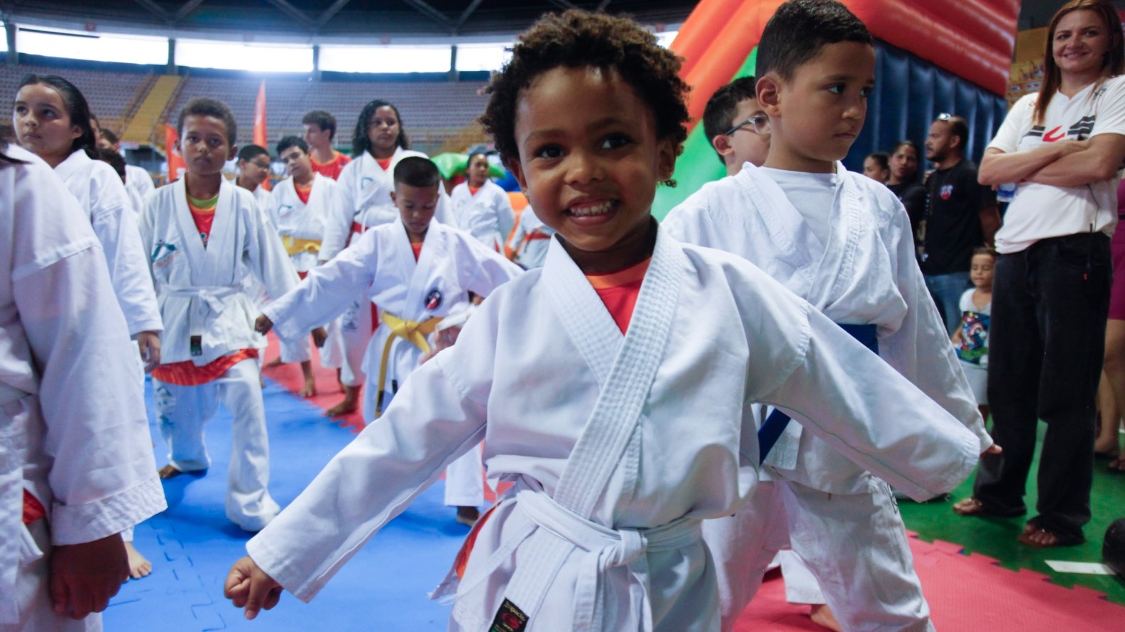 Um menino negro vestindo quimono posa para foto durante o evento