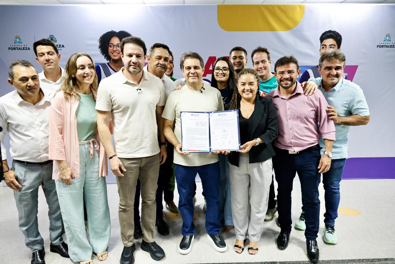 O prefeito Evandro Leitão, o presidente da Câmara Municipal, Leo Couto, gestores e representantes da Prefeitura posam para a foto com o termo de cooperação do programa assinado