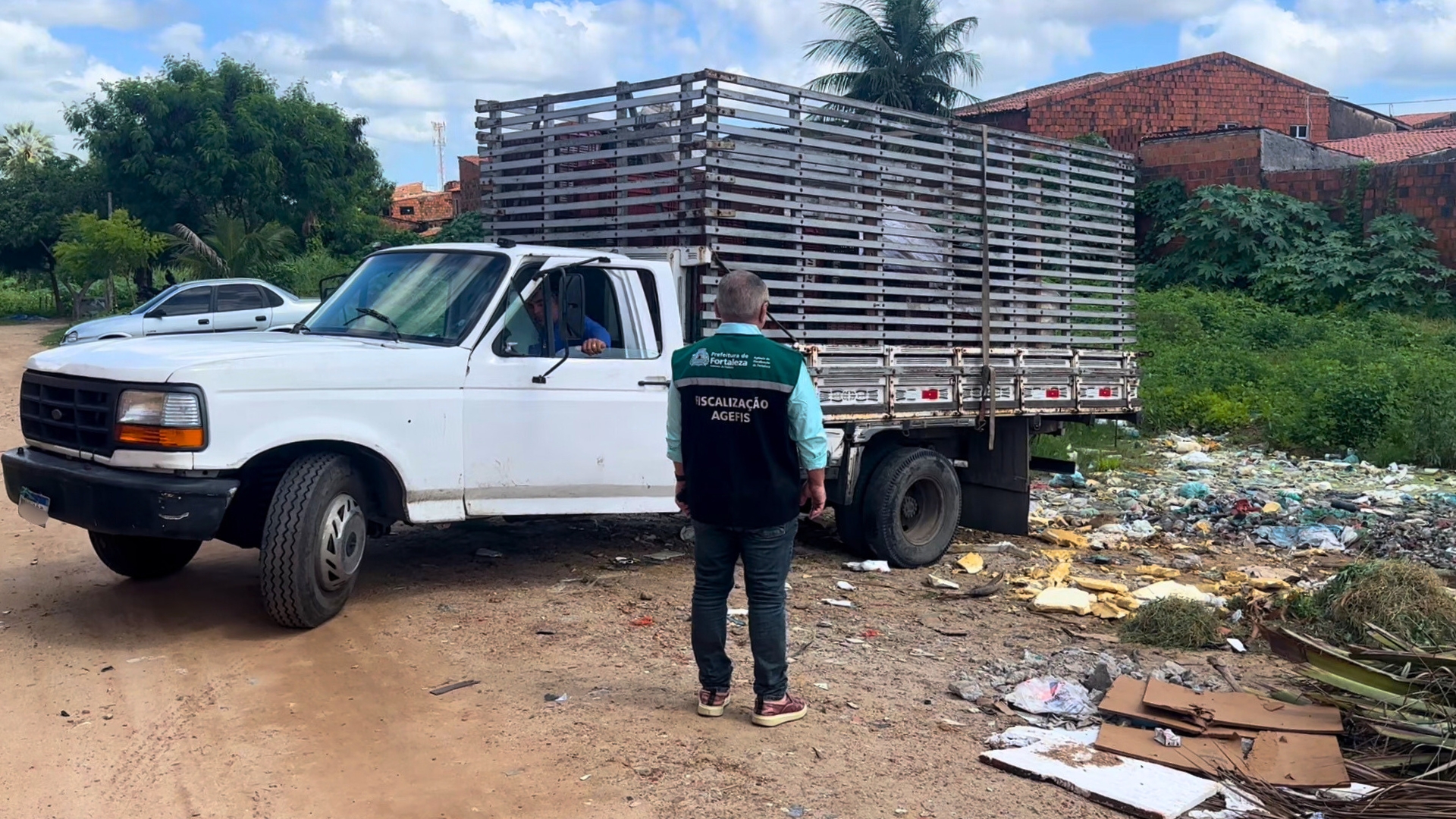 Fiscal da Agefis em frente a caminhão apreendido logo após descartar resíduos sólidos de forma irregular
