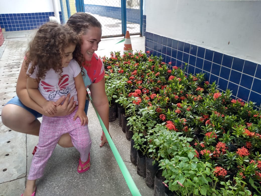 mãe e filha admirando as mudas de flores